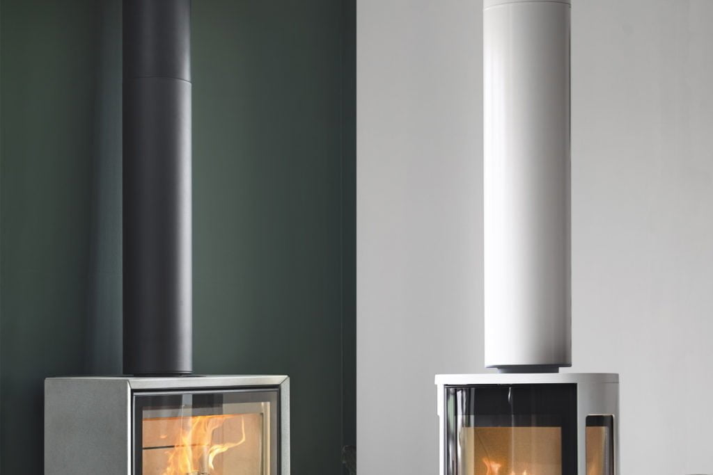Två moderna eldstäder, en med svart skorsten på grön vägg och en med vit skorsten på vit vägg, båda med synliga lågor.