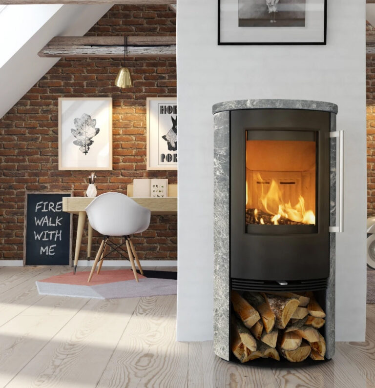 Modern kamin i ett stilfullt vardagsrum med tegelväggar och en arbetsplats. Elden brinner i kaminen, och ved förvaras under.
