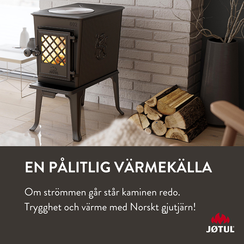 Gjutjärnskamin från Jøtul på golv vid tegelvägg, omgiven av vedträn. Text beskriver kaminen som en pålitlig värmekälla vid strömavbrott.