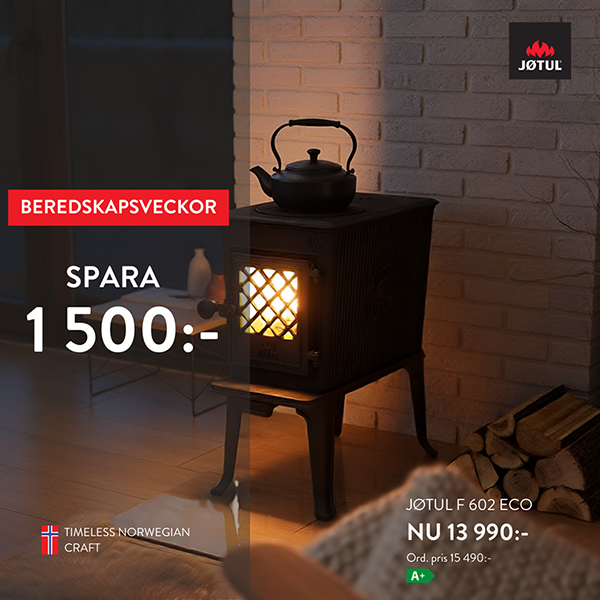 Vedeldad kamin Jøtul F 602 Eco i mysig interiör, erbjudande om 1 500 kr rabatt under beredskapsveckor, pris 13 990 kr. Norsk design, energieffektivitet A+.