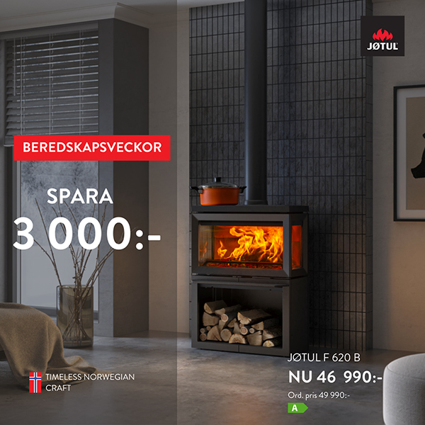 Modern vedeldad kamin i ett stilrent vardagsrum med erbjudande om att spara 3 000 kr. Jøtul F 620 B visas med brinnande eld och vedförvaring.