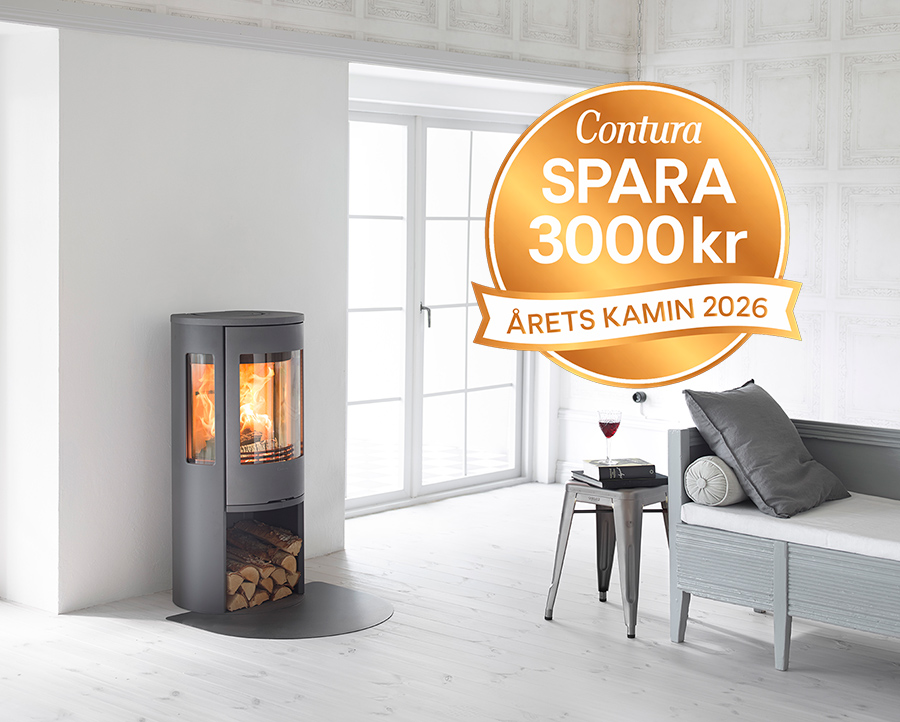 Modern kamin från Contura med brinnande eld, placerad i ett ljust rum. Intill står en soffa och ett bord med ett vinglas. Rabattmärke: "Spara 3000 kr, Årets Kamin 2026".