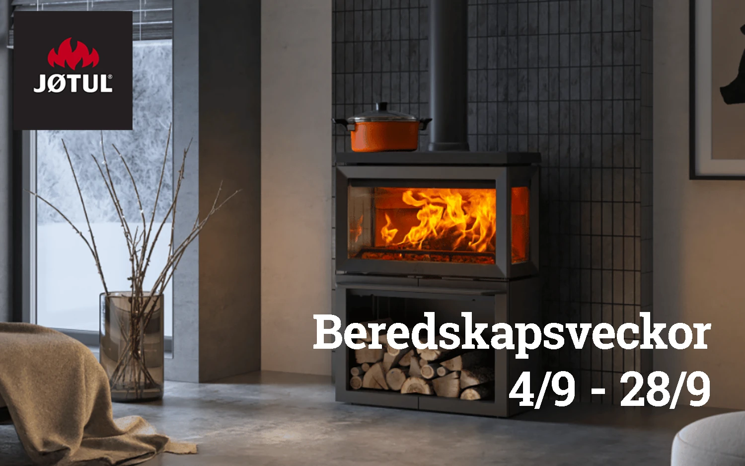 Modern eldstad med brinnande ved, kastrull ovanpå, vedförvaring under. Jøtul-logotyp och text "Beredskapsveckor 4/9 - 28/9". Mysig inomhusmiljö med fönster och dekoration.