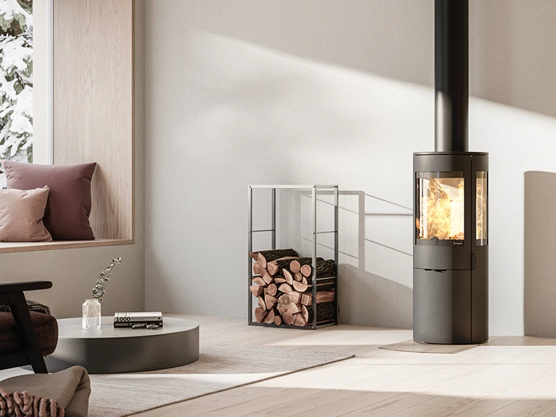 Modern kamin i stilren vardagsrumsmiljö med vedförvaring bredvid. Elden brinner klart i kaminen, vilket skapar en varm och inbjudande atmosfär.