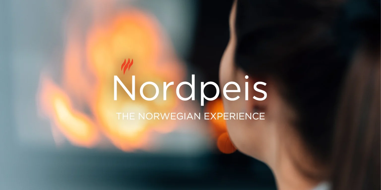 Kvinna framför en brinnande eld, Nordpeis logotyp och slogan "The Norwegian Experience" synlig. Fokus på värme och design.