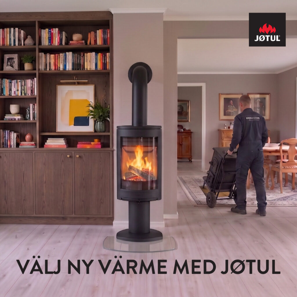 Modernt vardagsrum med en brinnande Jøtul-kamin framför en bokhylla. En person i arbetskläder flyttar en vagn i bakgrunden. Text: "Välj ny värme med Jøtul".